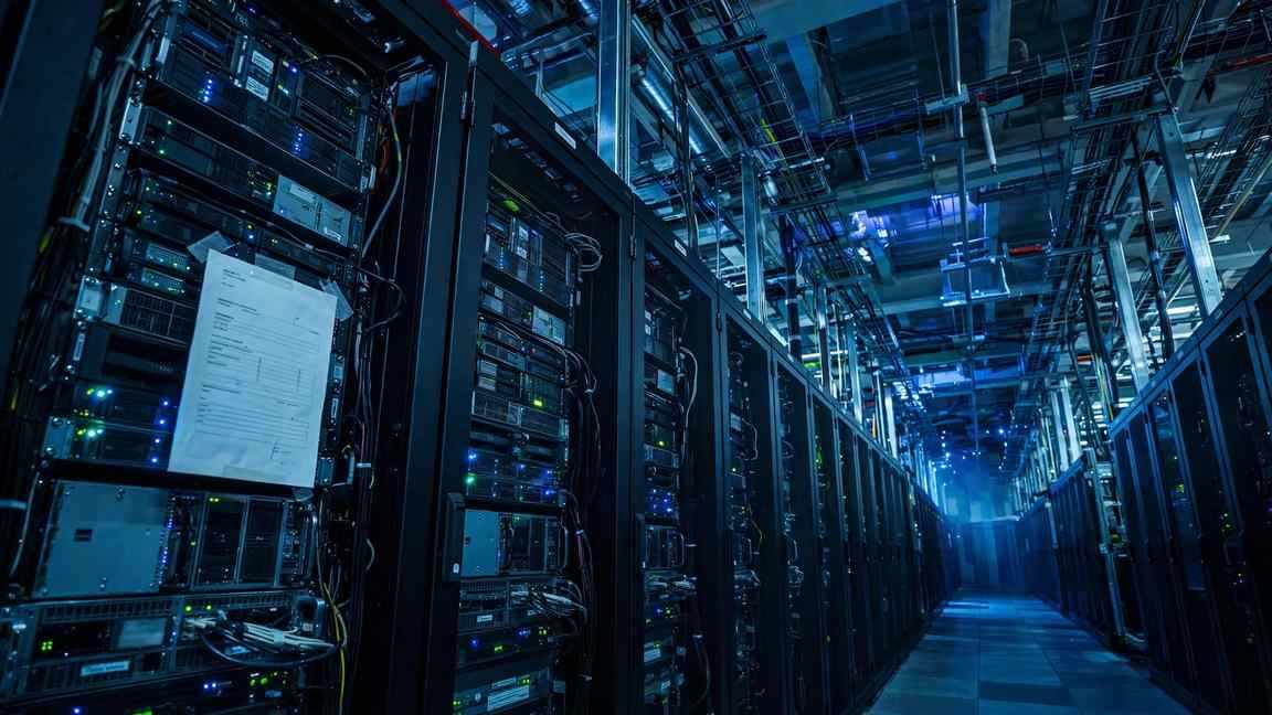A towering wall of server racks with a single invoice taped to the nearest one.